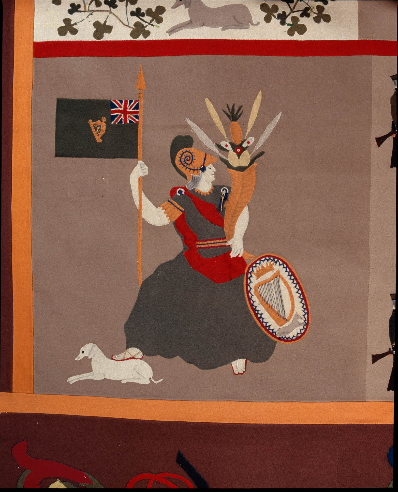 20060619_NMIDT-1960-42_Stokes_detail_22_2000px-(4).jpg Close-up of a panel on the Stokes Tapestry depicting a female figure holding a cornucopia, a shield, and a flag with a dog at her feet.